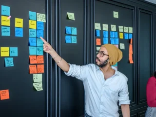 team arranging sticky notes on a project board