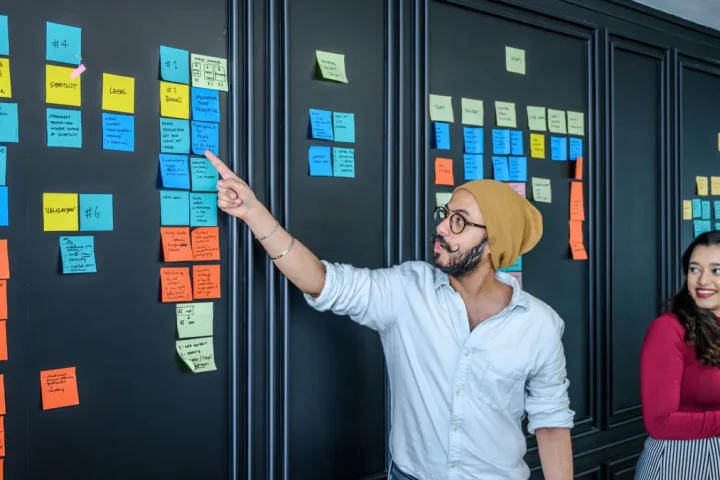 team arranging sticky notes on a project board