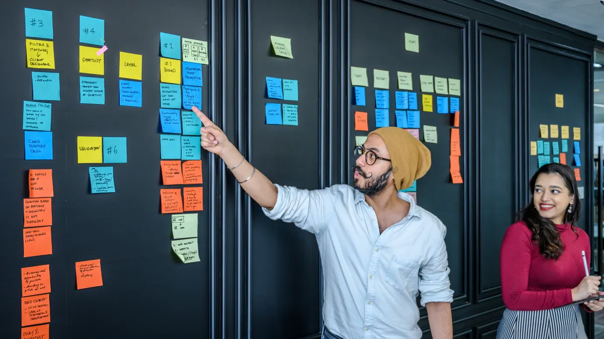 team arranging sticky notes on a project board