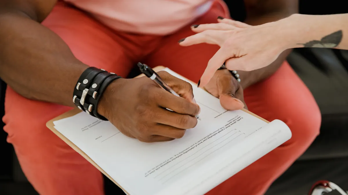 How to build a SaaS intake form that reduces bad purchases two people reviewing and signing a form