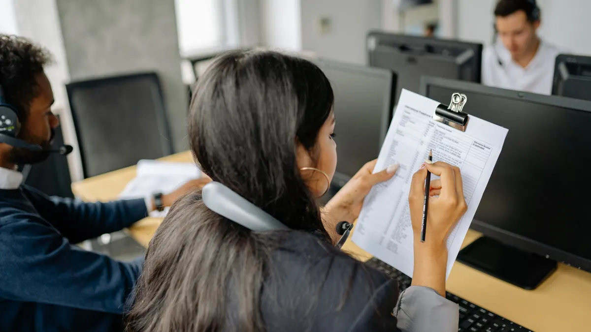 How to evaluate SaaS support quality before purchase support staff in headsets reviewing documents at computers