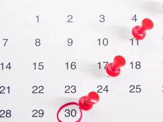 Monthly calendar with red pins marking important dates
