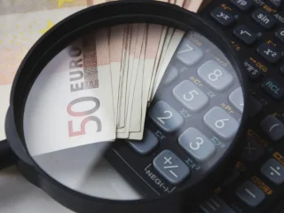 Magnifying glass over euro notes and calculator