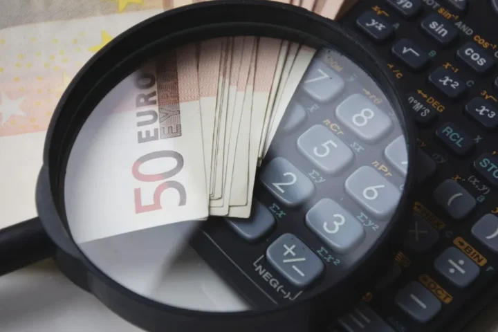 Magnifying glass over euro notes and calculator