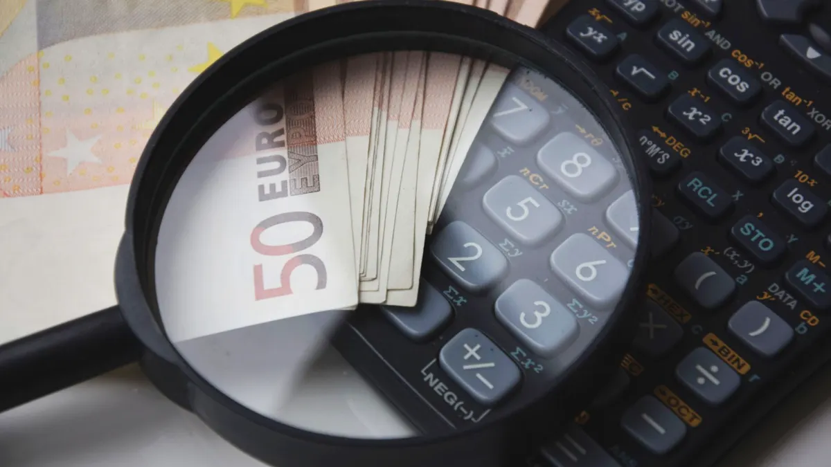 Magnifying glass over euro notes and calculator